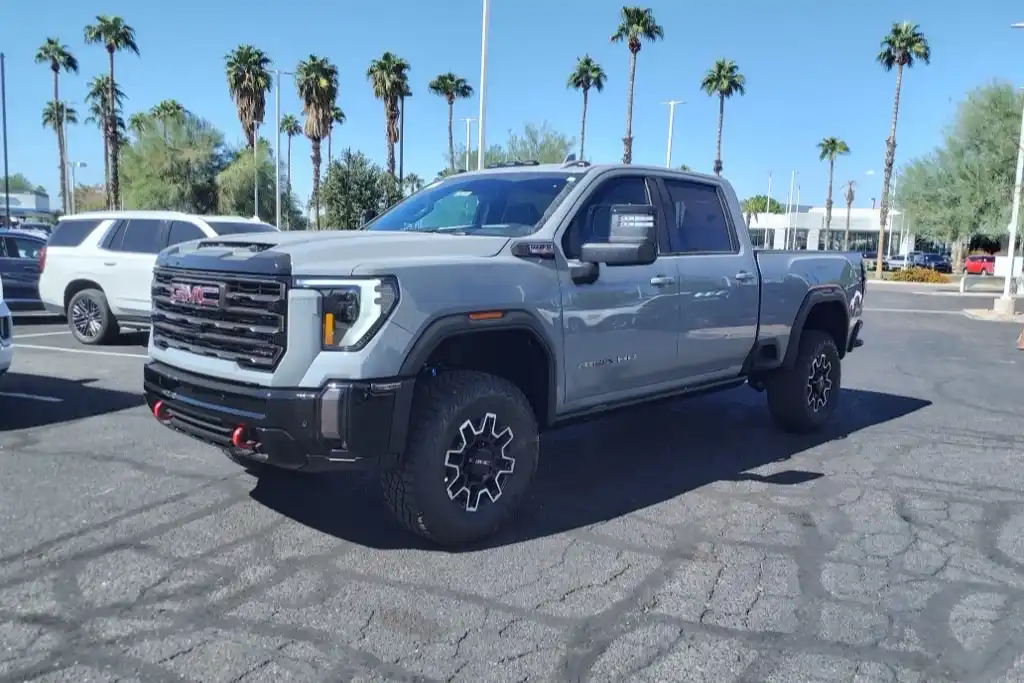 A lifted heavy-duty diesel pickup on off-road tires parked under palm trees against a clear Arizona sky, the kind of truck Anthem owners tow with