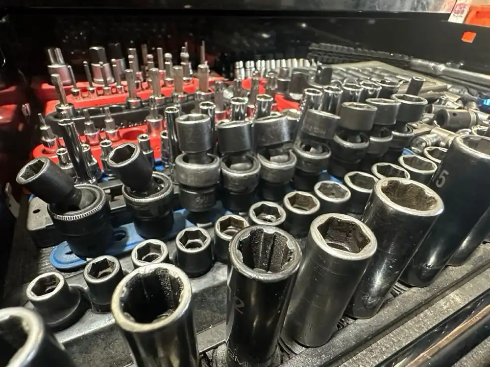 Close-up of a Floorjack Auto Repair tool drawer packed with impact sockets, hex bits and drivers in red and blue trays