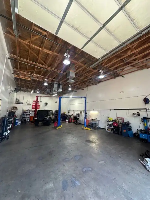 A vehicle on the lift inside the Floorjack Auto Repair service bay in Phoenix, where AC and cooling-system work is done